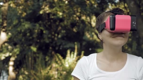 Mulher explora realidade virtual usando óculos VR — Vídeo de Stock