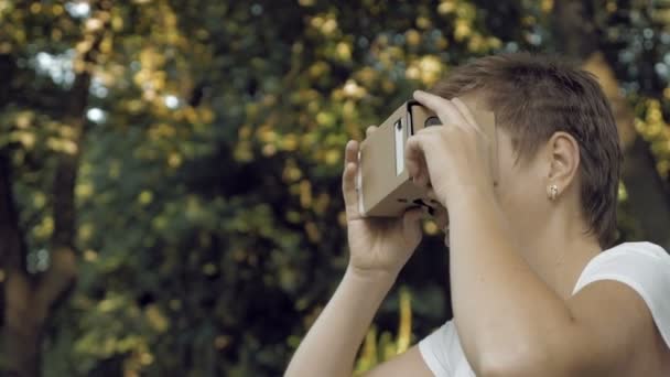 Exploring virtual reality in cardboard VR glasses — Stock Video