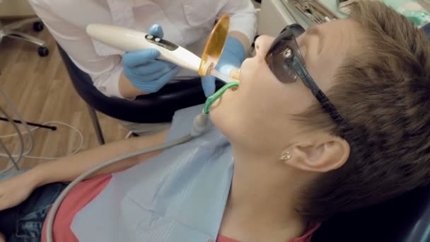 Vrouw krijgt tandheelkundige hulp om te vullen een holte in een tand — Stockvideo