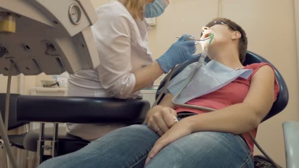 Frau zur Behandlung in die Zahnarztpraxis — Stockvideo