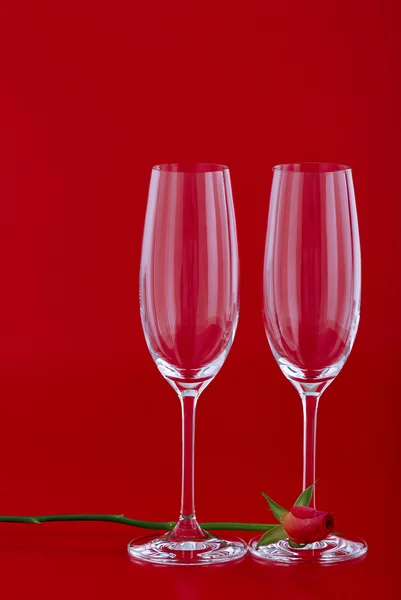 Two wine glasses with rose flower over red — Stock Photo, Image