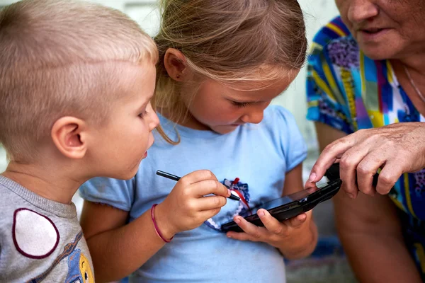 Crianças brincam com smartphone — Fotografia de Stock