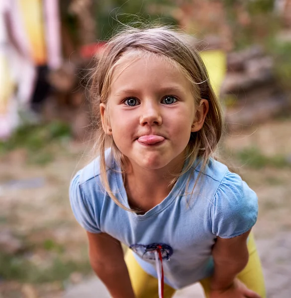 Маленька дівчинка дражнить і викладає язик — стокове фото