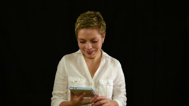 Szép mosolygó fiatal nő textil a Tablet pad — Stock videók