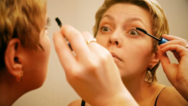 Mujer rubia bonita aplicando maquillaje de rímel — Vídeos de Stock