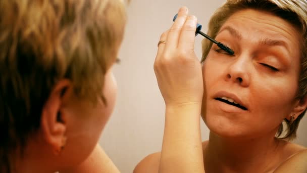 Bella donna bionda che applica il trucco mascara — Video Stock