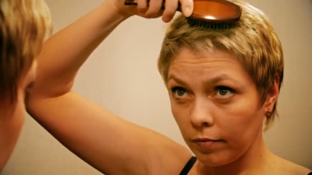 Jolie femme blonde peigne et brosse ses cheveux — Video