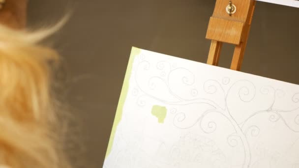 Художница рисует картины в художественной студии — стоковое видео