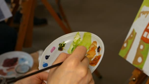 Графічний художник, що змішує кольорові фарби олій в палітрі — стокове відео