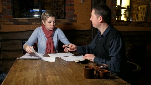 Чоловік і жінка партнери підписують контракт в кафе — стокове відео
