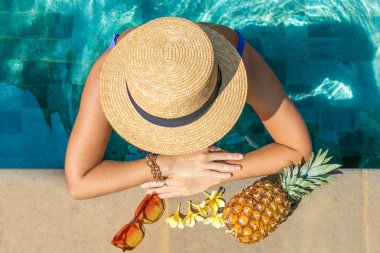 Havuzda şapkası olan Avrupalı bir kadın, yukarıdan manzaralı. Yaz konsepti.