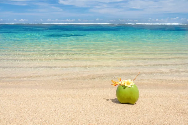 Cóctel de coco decorado con flores en la playa. — Foto de Stock