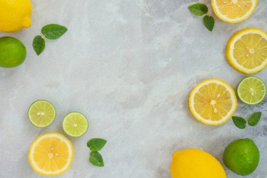 Düz, sulu limon ve kireç gri mermer zemin üzerine serilmiş. Üst görünüm, alanı kopyala.