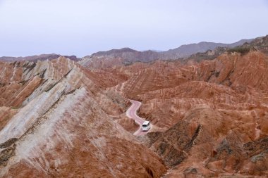 Gökkuşağı Dağı 'nın muhteşem manzarası ve gün batımında mavi gökyüzü arkaplanı. Zhangye Danxia National Geopark, Gansu, Çin. Renkli manzara, gökkuşağı tepeleri, sıra dışı renkli kayalar, kumtaşı erozyonu.