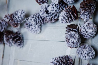 Noel ve yeni yıl kompozisyonu. Ahşap beyaz arka planda çam kozalakları. Fotokopi alanı olan ladin ve kozalaklı eski dokulu arka plan. Xmas 'la tanışma konsepti ve mutlu yıllar