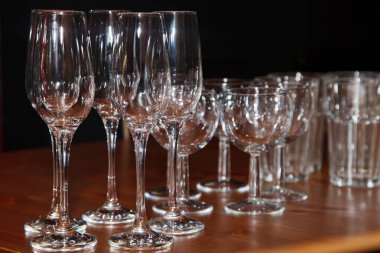 Mutfaktaki boş bardaklar masada. Odadaki boş bardaklar. Şarap, şampanya ve içki için temiz tabaklar. Boşluğu kopyala