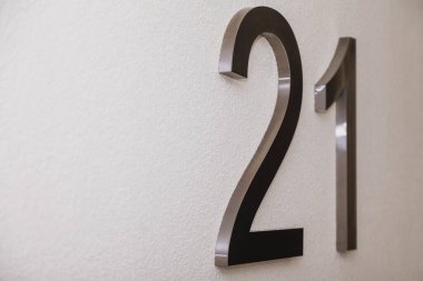 Doku aydınlatma duvarında yirmi bir numara, 2021 yılını simgeliyor. Krom numaralar, yüzeysel beyaz renk gradyan zemin üzerinde 21. İki ve bir numaralı tek renkli arka plan. Boşluğu kopyala