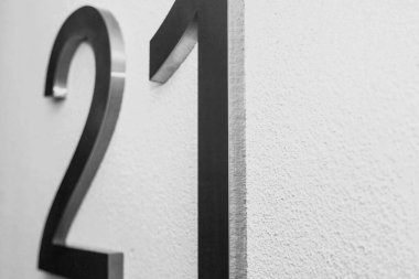 Doku aydınlatma duvarında yirmi bir numara, 2021 yılını simgeliyor. Krom numaralar, yüzeysel beyaz renk gradyan zemin üzerinde 21. İki ve bir numaralı tek renkli arka plan. Boşluğu kopyala
