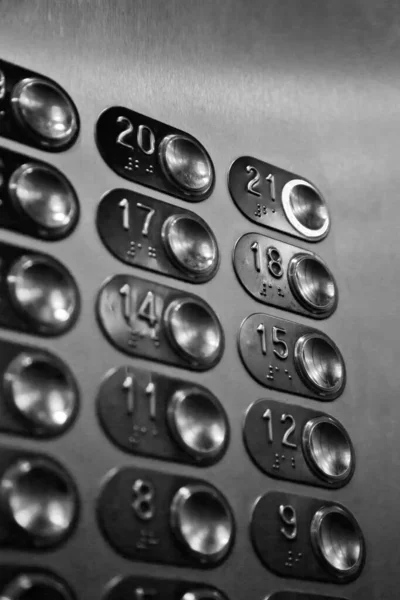 Floor buttons in elevator with number 21 twenty-one pressed. Chrome control panel for elevator movement close-up in multi-storey building. Traffic, transportation. Lots of buttons on elevator wall