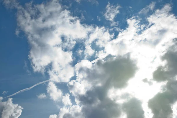 Clouds in blue sky. White, fluffy clouds In blue sky. Background nature. Texture cumulus floating on blue sky. Environment, atmosphere. Place for banner, site an inscription text or logo. Copy space