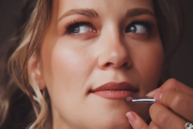 Makyöz, düğün gününde otel odasında genç ve güzel bir kadın geline makyaj yapmış. Güzel genç bayan damatla tanışmaya hazırlanıyor. Mutluluk ve lüks evlilik kavramı. Boşluğu kopyala