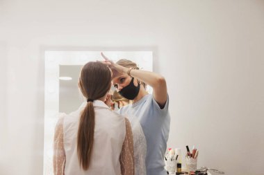 Kadın makyaj sanatçısı güzellik salonunda güzel bir kadın yaratıyor. Dahili salondaki müşteri hizmetleri inanılmaz bir imaj yaratıyor. Makyaj yaratma sihirbazı. Ölçülü tatmin kavramı. Boşluğu kopyala