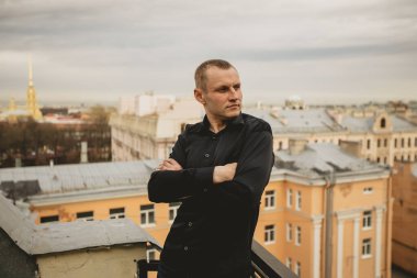 Koyu arkaplanda zarif ve yakışıklı bir adamın portresi. Lüks stüdyo moda portresi. Adam iddialı ve ilgili görünüyor. İşine ciddi bir yaklaşım ve sonuç olarak kendine güven kavramı