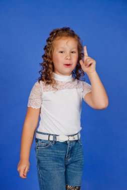 Eureka işareti mi yoksa harika bir fikir mi? Şık küçük kızın duygusal portresi parmağını kaldırıyor ve parlak bir fikirden esinlenmiş gibi görünüyor. Ani akıllıca bir karar vermek, bir numaralı jest. Boşluğu kopyala