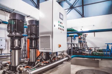 Su pompasının, vanaların, basınç göstergelerinin, makine dairesinin içindeki motorların endüstriyel içleri. Endüstriyel bir odada valf ve pompalar. Kentsel modern güçlü boru hatları ve pompalar, otomatik kontrol sistemleri