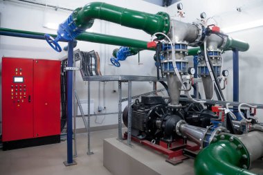 Su pompasının, vanaların, basınç göstergelerinin, makine dairesinin içindeki motorların endüstriyel içleri. Endüstriyel bir odada valf ve pompalar. Kentsel modern güçlü boru hatları ve pompalar, otomatik kontrol sistemleri