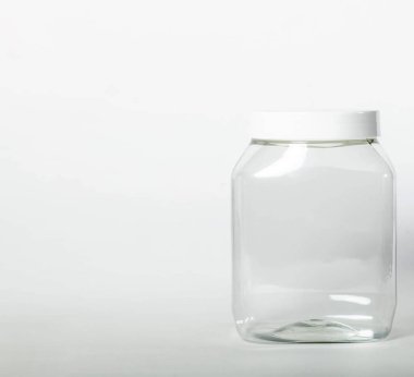 Cans for storing bulk products with white lids on light isolated background. Transparent plastic container with lid for storing food and bulk product. An empty jar for food. Copy space