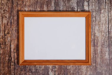 Ahşap arka planda boho tarzı fotoğraf çerçevesi boş. İzole edilmiş beyaz ışıklı ahşap çerçeve çizimi sanat eseri, harf ya da logo için yatay işaret. Site için telif hakkı alanı