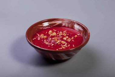 Açık gri arka planda soğan cipsli pancar kremalı sebze çorbası. Kahverengi tabakta soğanlı geleneksel kremalı borş çorbası. Vejetaryen çorbası borş domates, havuç, zeytinyağı. Boşluğu kopyala