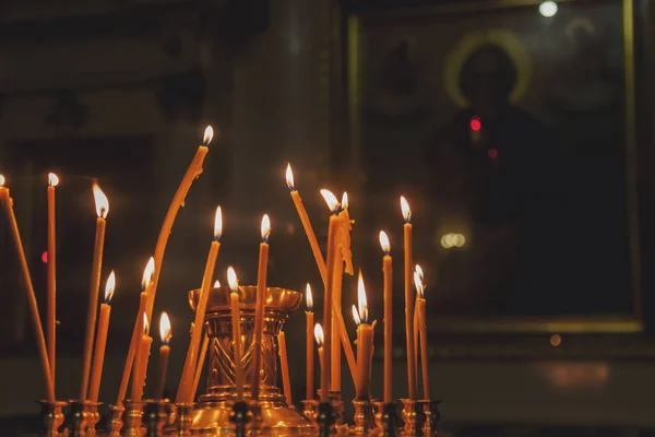 许多人在东正教教堂或庙宇中点燃蜡蜡烛 准备举行复活节仪式 背景橙色的蜡烛在正宗的寺庙里燃烧 教会创造力背景的概念 网站的复制空间 — 图库照片