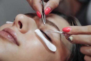 Güzellik salonundaki hoş genç bayana kirpik uzatma işlemi. İçişleri odasındaki müşteri hizmetleri inanılmaz bir imaj yaratıyor. Makyaj yaratma sihirbazı. Kavram tarzı, kozmetik tatmin. Boşluğu kopyala