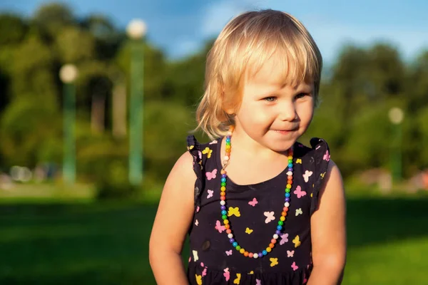 可爱的金发碧眼的小女孩两岁的时候和泰迪熊一起在鲜绿的草地上开着花 孩子们在修剪的天然草坪上迈出了第一步 玩得很开心 幸福和健康的童年概念 — 图库照片