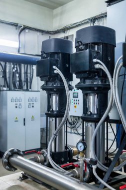 Su pompasının, vanaların, basınç göstergelerinin, makine dairesinin içindeki motorların endüstriyel içleri. Endüstriyel bir odada valf ve pompalar. Kentsel modern güçlü boru hatları ve pompalar, otomatik kontrol sistemleri