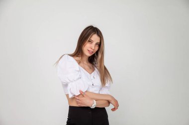 Saçları neşeli bir şekilde gülümseyen, mutlu ve kaygısız hissederken duygularını gösteren güzel sarışın bir kadının sıradan portresi. Genç, tatlı, neşeli kız beyaz arka planda kameraya bakıyor.