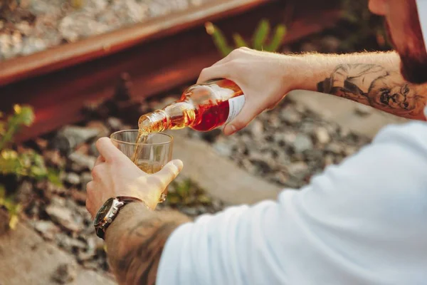 Giovane Uomo Beve Alcol Una Ferrovia Abbandonata Campagna Tramonto Concetto — Foto Stock