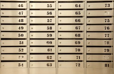 Bir apartmandaki çelik posta kutuları. Hatta sıra sıra numaralandırılmış posta kutusu. Şehirdeki yazışma konsepti. Bunu yaratıcılığın için arka plan olarak kullanabilirsin. Boşluğu kopyala