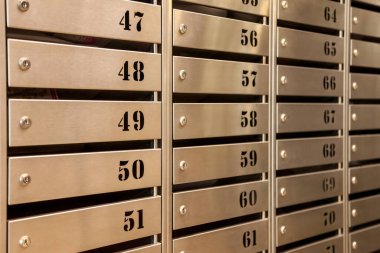 Bir apartmandaki çelik posta kutuları. Hatta sıra sıra numaralandırılmış posta kutusu. Şehirdeki yazışma konsepti. Bunu yaratıcılığın için arka plan olarak kullanabilirsin. Boşluğu kopyala