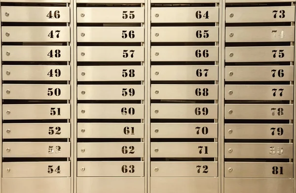 Steel Mailboxes in an apartment residential building. Even rows of numbered mailbox. Correspondence concept in city. You can use it as background for your creative. Copy space