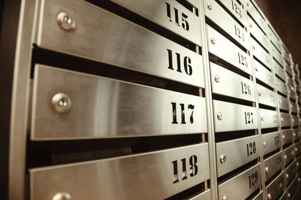 Steel Mailboxes in an apartment residential building. Even rows of numbered mailbox. Correspondence concept in city. You can use it as background for your creative. Copy space