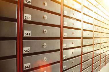 Bir apartmandaki çelik posta kutuları. Hatta sıra sıra numaralandırılmış posta kutusu. Şehirdeki yazışma konsepti. Bunu yaratıcılığın için arka plan olarak kullanabilirsin. Boşluğu kopyala