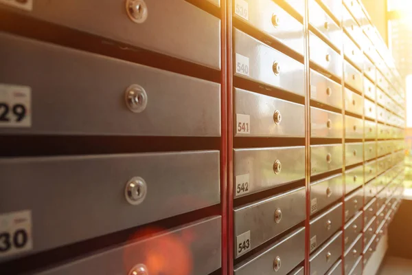 Steel Mailboxes in an apartment residential building. Even rows of numbered mailbox. Correspondence concept in city. You can use it as background for your creative. Copy space