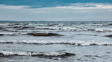 Atmosferik manzara dramatik Baltık denizi, dalgalar ve su dalgalanma sularına sıçrar. Deniz kıyısındaki doğa, kuzey bulutları. Kararsız hava koşulları, iklim değişikliği. Fırtınalı, soyut arka planlar
