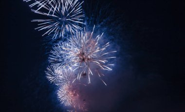 Kara gece gökyüzü evreninde kıvılcımları, renkli yıldızları ve parlak nebulası olan bayram havai fişekleri, kuyruklu yıldızları. İnanılmaz güzel, renkli havai fişekler kutlamada, gösterimde. Tatil geçmişleri