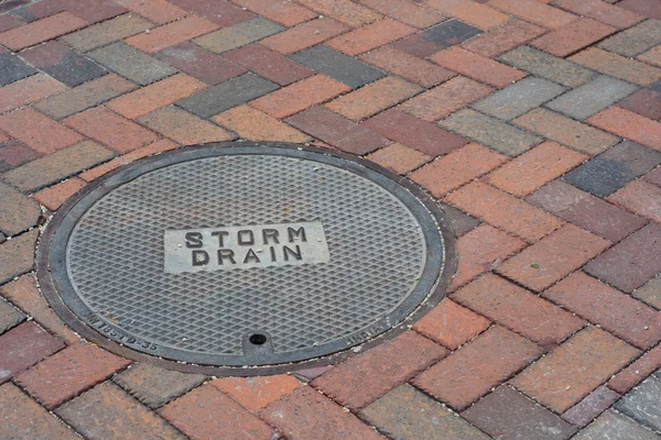 Storm Drain Cover on a Brick Road — Stock Photo, Image