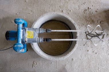 İnşaat mikseri çözümü olan bir konteynırın üzerinde yatıyor.,