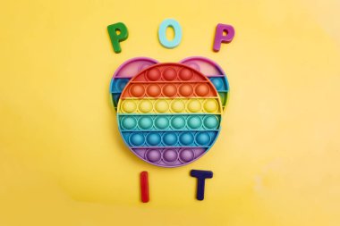 Oyuncak sarı arka planda yatıyor, yazıt onu açıyor.